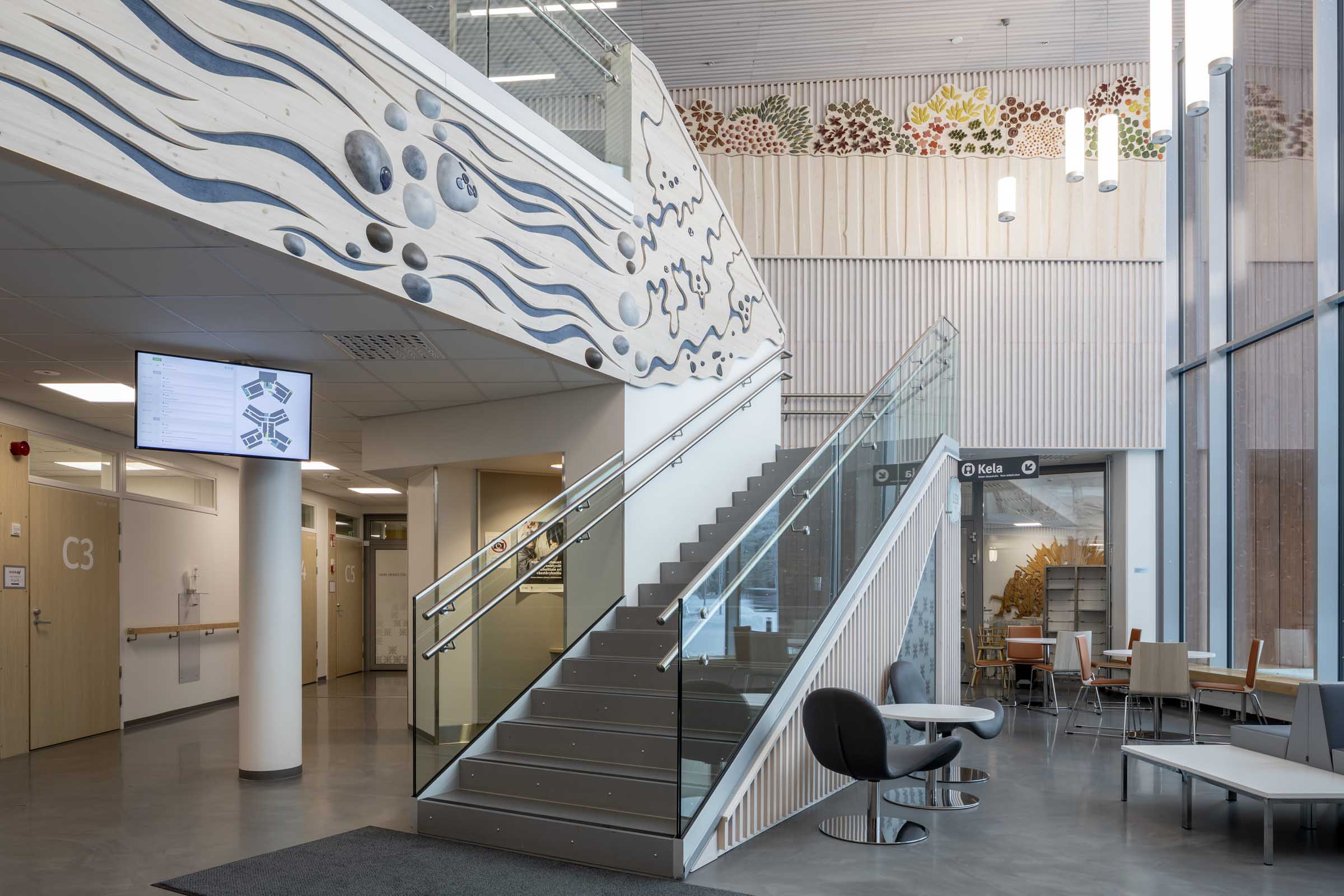Sodankylän hyvinvointikeskus "Sopukka", portaat ja luontoaiheiset seinäreliefit aulatilassa.